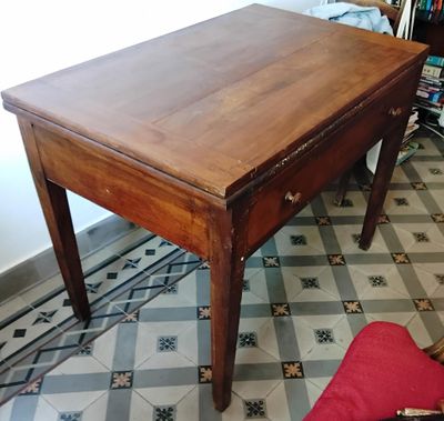 une petite table en bois avec une chaise rouge devant