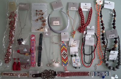 many different necklaces and bracelets displayed on a table