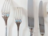 four forks, a knife, and a spoon sitting on a table