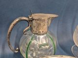 three glass dishes and a silver pitcher on a table
