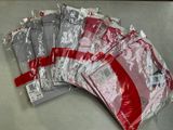 plusieurs sacs remplis de t-shirts rouges et blancs posés sur une table