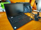 un ordinateur portable posé sur un bureau, à côté d'un sac