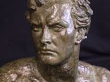 bronze bust of a man on a marble base on a black background