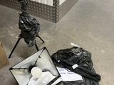 un sac poubelle posé par terre à côté d'un trépied