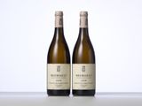 deux bouteilles de vin posées sur une table l'une à côté de l'autre