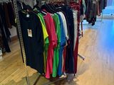 a rack of clothes in a clothing store with a lot of clothes on it
