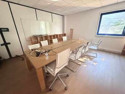 des tables et des chaises dans une pièce avec une grande fenêtre en arrière-plan