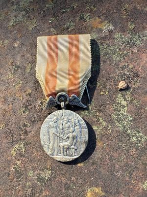 a medal on the ground next to a coin