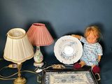 une poupée assise à côté d'une table sur laquelle se trouve une assiette