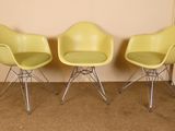 trois chaises jaunes placées les unes à côté des autres sur un sol recouvert de moquette