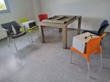 brightly colored chairs and a table in a room with a window