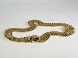 a close up of a gold chain with a clasp on a white surface
