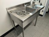 a stainless steel sink in the corner of a room