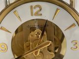 a gold clock with a white face and gold hands