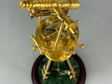 a gold plated model of a telescope on a stand