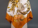 an orange and white scarf with a floral design on it