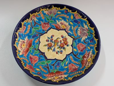 a blue and yellow plate with a floral design on it