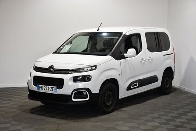 la camionnette blanche est garée dans une pièce au sol en damier