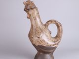 a small vase that has a bird on top of it