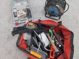 un sac rouge contenant des outils, posé par terre