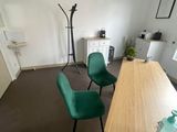 une pièce avec un bureau, des chaises et une horloge accrochée au mur