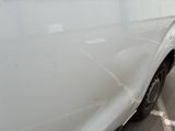 a close up of a white car with a denting on it