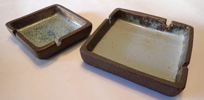 two small square dishes sitting on a table