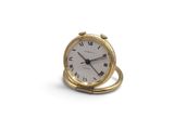 a small gold clock with roman numerals on it