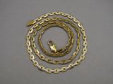 a gold chain with a clasp on a gray surface