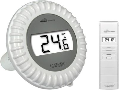 a white alarm clock with a remote control next to it