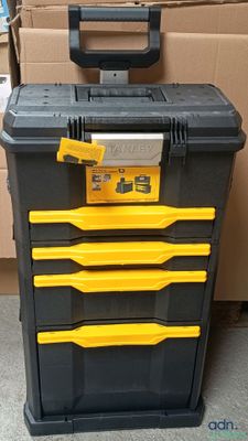 a black and yellow tool box sitting on top of a pile of boxes