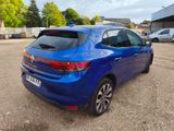 the rear end of a blue car parked in a parking lot