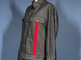a black leather jacket with red and white stripes on a mannequin stand
