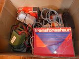 une boîte posée par terre, contenant du matériel électrique