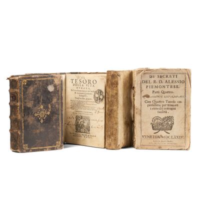 two old books sitting on top of each other on a white surface