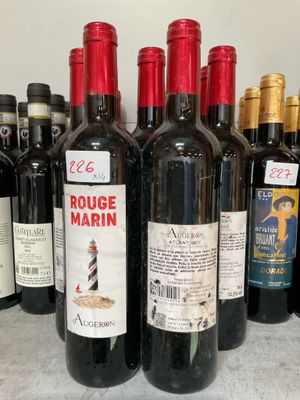 plusieurs bouteilles de vin rouge sont alignées sur un comptoir
