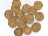 some gold coins on a white surface with a white background