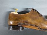 a pair of brown shoes hanging on a wall
