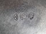 a close up of a silver plate with three different symbols on it