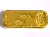 gros plan d'un lingot d'or sur une surface blanche
