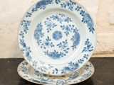 une assiette bleue et blanche et une assiette posée sur une table noire