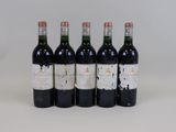 four bottles of wine are lined up on a white surface