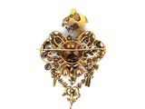 an image of a gold broochle with a bird on it