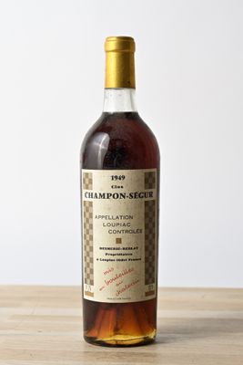 une photo d'une bouteille de vin posée sur une table en bois