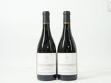 deux bouteilles de vin rouge posées sur une table blanche