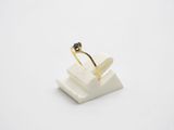 a gold ring with a black diamond sits on top of a white marble block