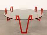 a glass table with red legs and a glass top