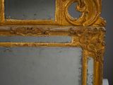 a mirror with a gold frame on a white surface