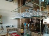une étagère en verre sur laquelle sont posés des verres à vin et des bouteilles