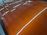 a brown car with a white stripe on it ' s hood